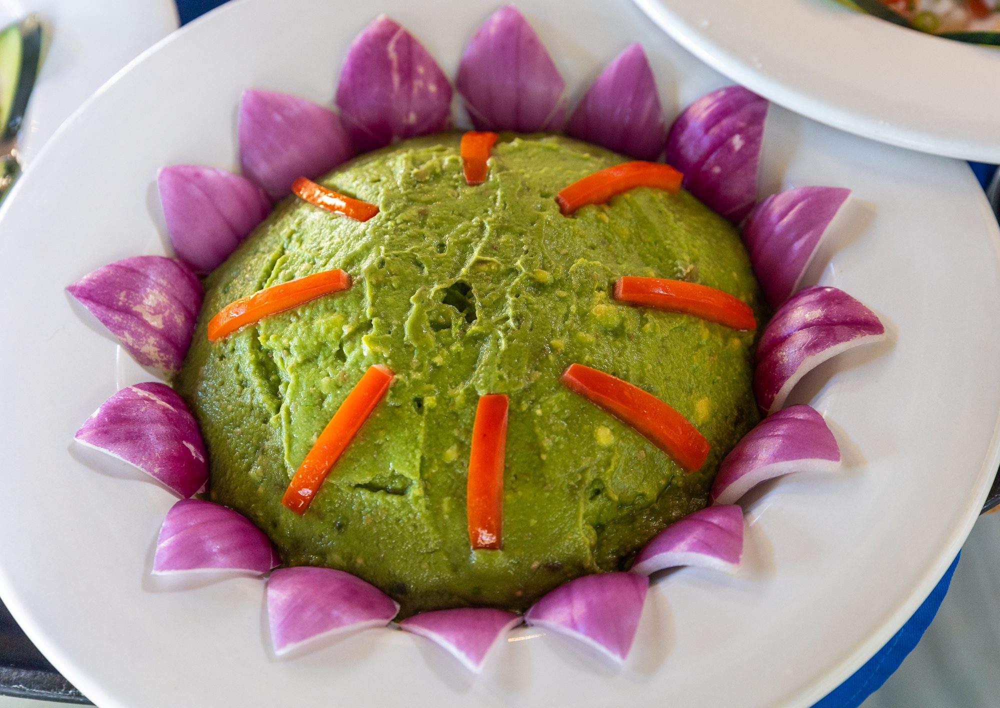 A chef's guacamole presentation ringed with red onion petals at the estate restaurant