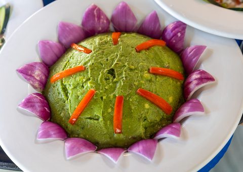 A chef's guacamole presentation ringed with red onion petals at the estate restaurant