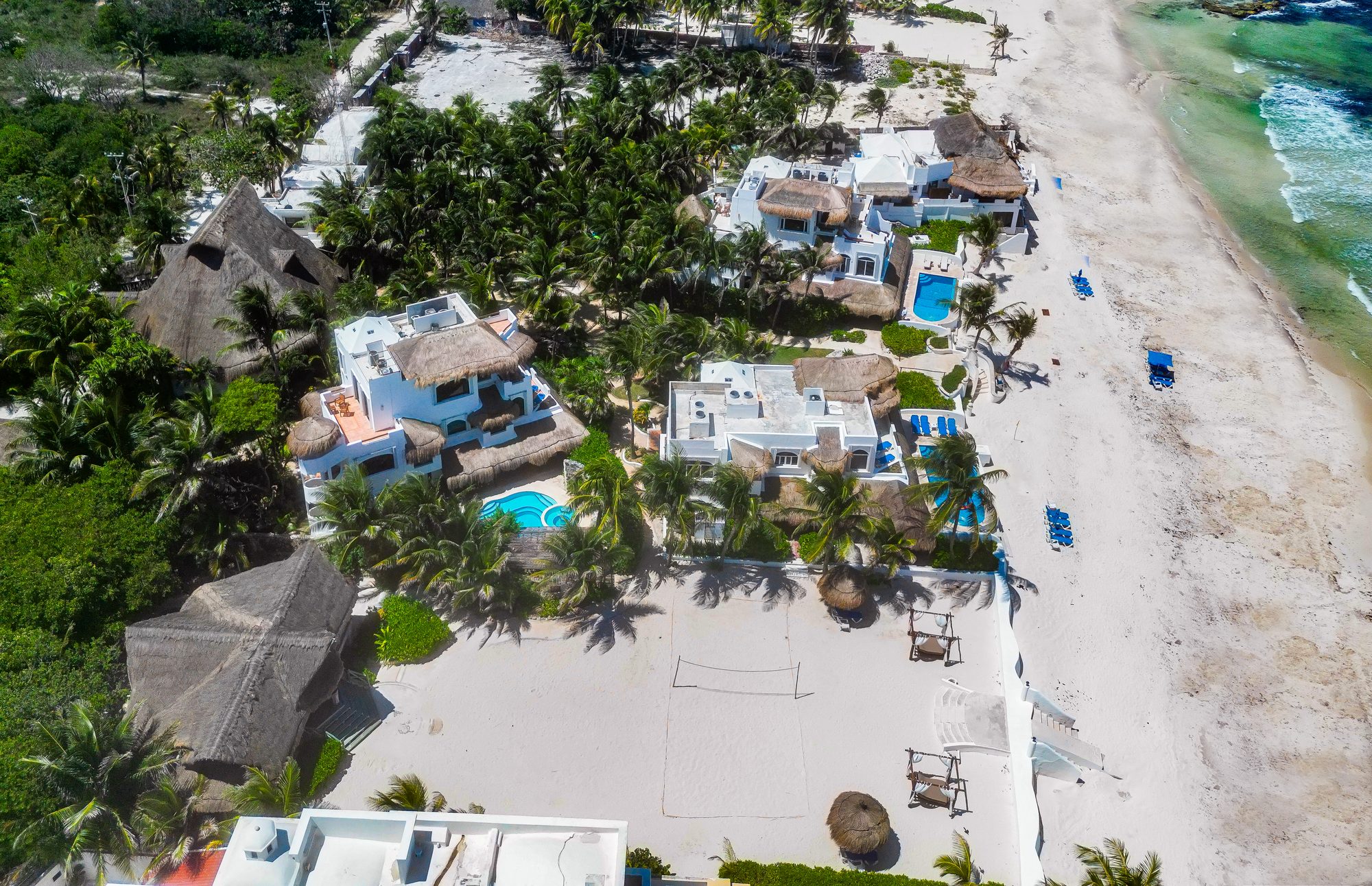 Oblique aerial of the estate's shoreline with villas and the open event sand by the water