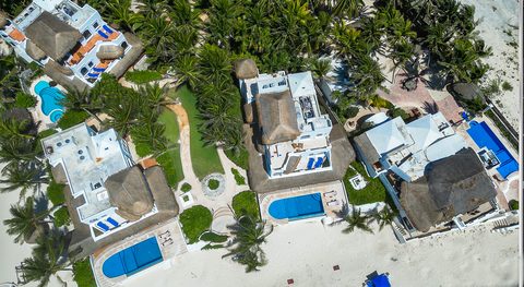 Aerial view of Hacienda del Secreto's beachfront villas and pools on Playa del Secreto