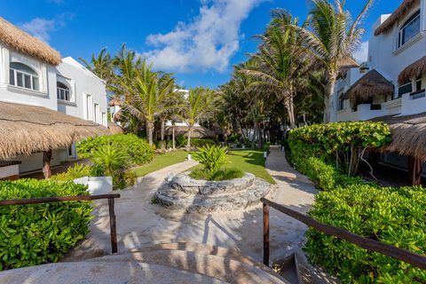 Stone garden paths winding between the estate's villas under coconut palms