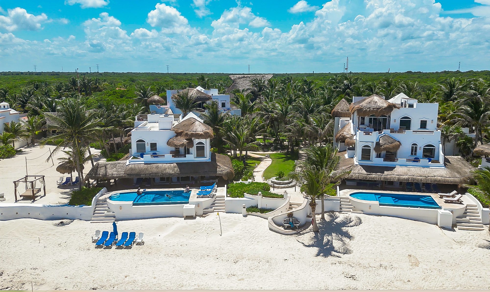 Two estate villas sharing a garden path that leads to the beach