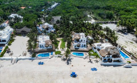 Aerial view of Hacienda del Secreto's beachfront villas and pools in a row on Playa del Secreto