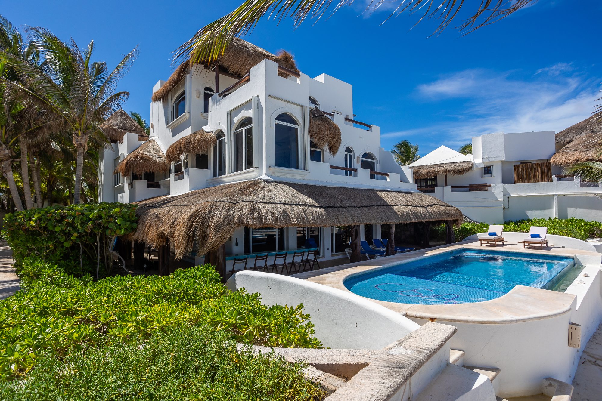 Villa Sarita's whitewashed facade and palapa roof above its beachfront pool