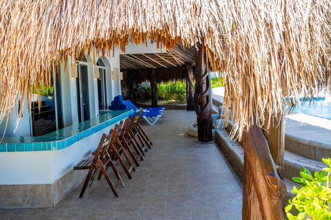 Villa Sarita’s turquoise-tiled terrace bar under deep thatch beside the pool