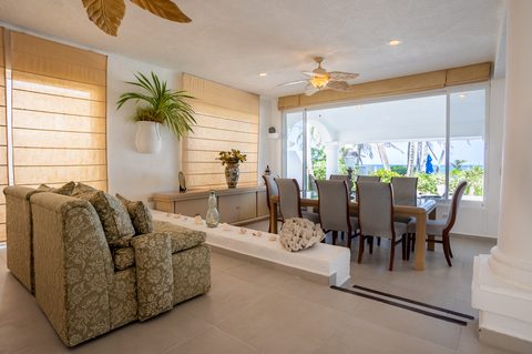Villa Tortuga’s living and dining room opening to palms and the sea