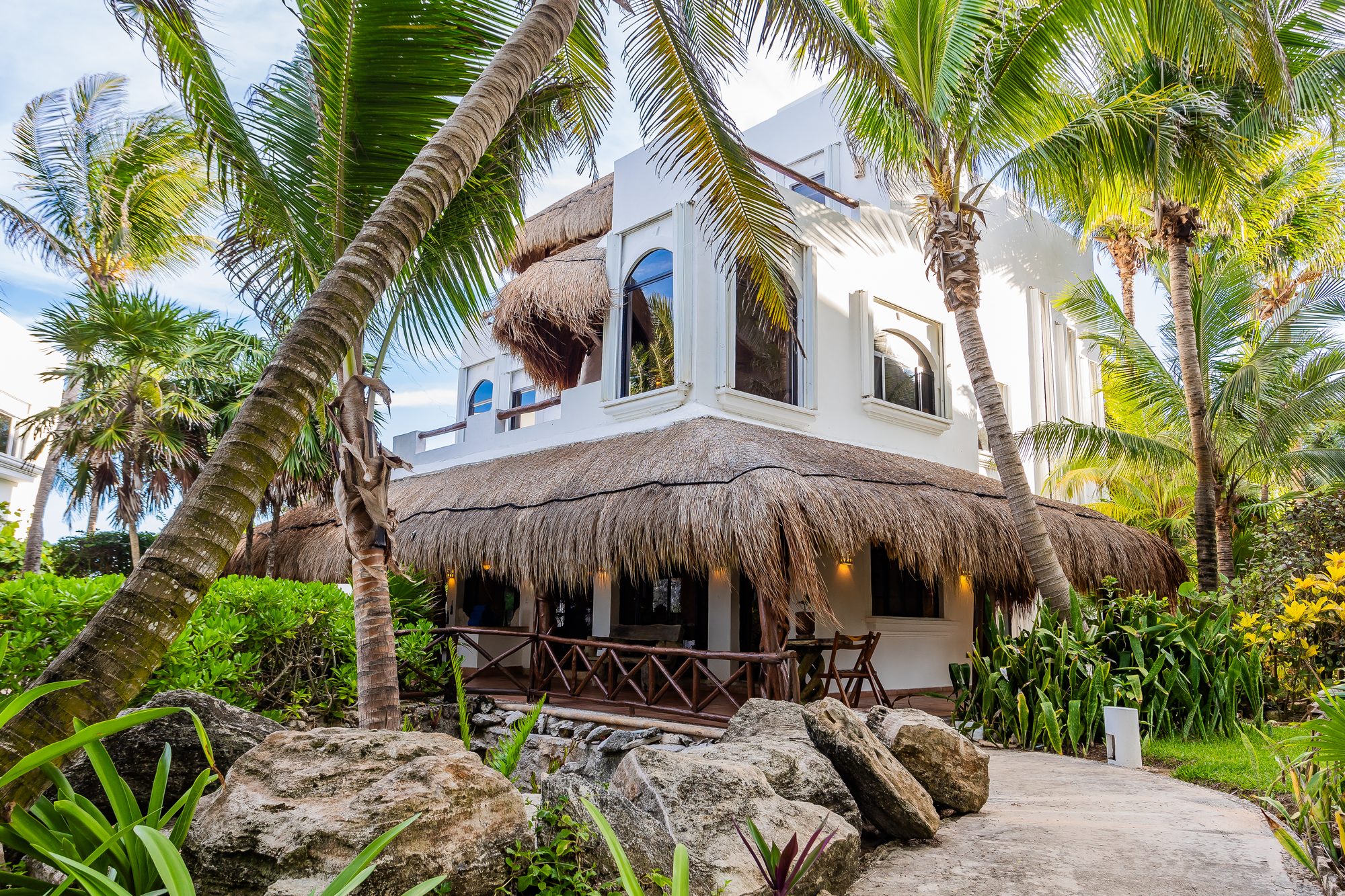 Villa Umakiha’s three whitewashed levels rising through the palms behind garden boulders